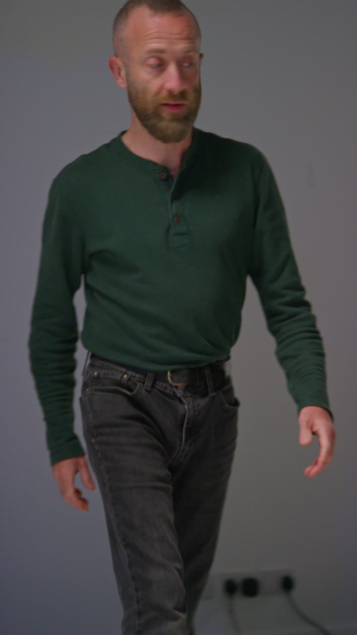 Vertical Video Of Male Film Lighting Technician Adjusting Lights For Shooting Movie Or Video In Studio Shot In Real Time