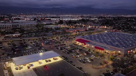 timelapse of hotels and commercial buildings with lots of lights and moving traffic at night time in san bernardino california west coast transitioning to dark scene aerial dolly push