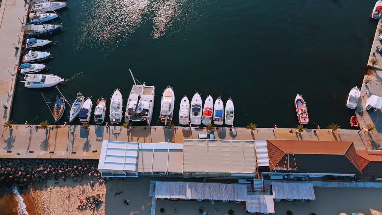 Rising over the pier with modern yachts standing by. Car rides by the waterfront