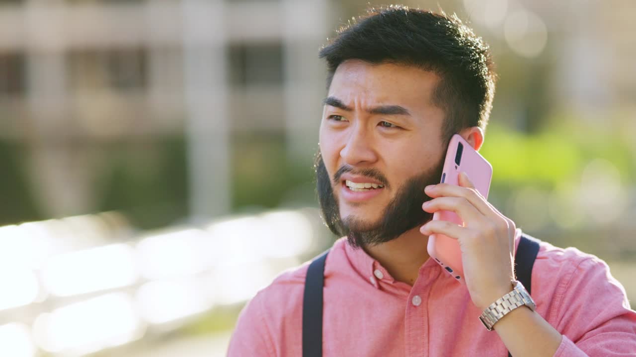 스타일리시한 아시아인 남자가 야외에서 전화로 논쟁하고 있습니다.