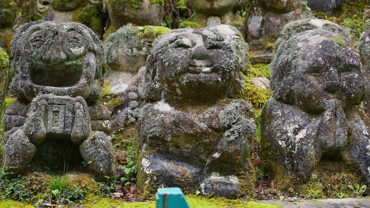 Moss-covered arhat statues covering the hillside around the temple grounds at the Otagi Nenbutsuji Temple in Kyoto, Japan