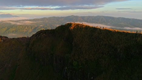 majestic aerial footage of mount batur in bali during sunrise. glowing volcanic peaks, morning mist, and golden skies create a stunning scene—ideal for nature, travel, and adventure content