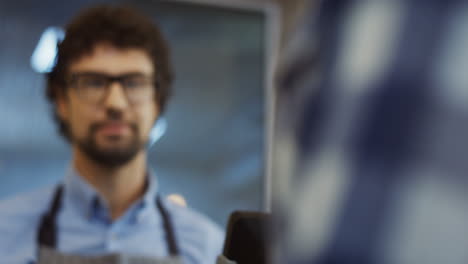 Close-Up-Of-The-Female-Buyer's-Hand-Giving-A-Credit-Card-To-The-Male-Vendor-In-Glasses-And-He-Withdrawing-Money-From-It-In-The-Bakery-Shop