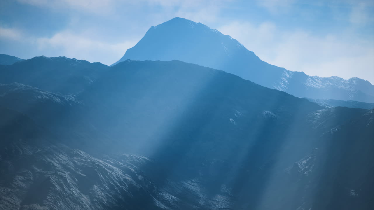 朝日に照らされた山々、柔らかな光線が山頂を照らす。