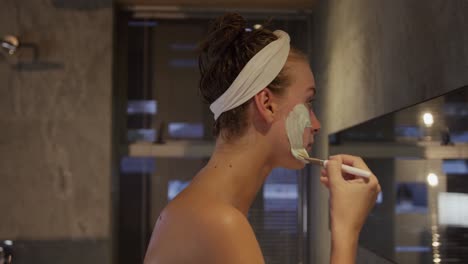 mujer caucásica poniendo una máscara facial en el hotel