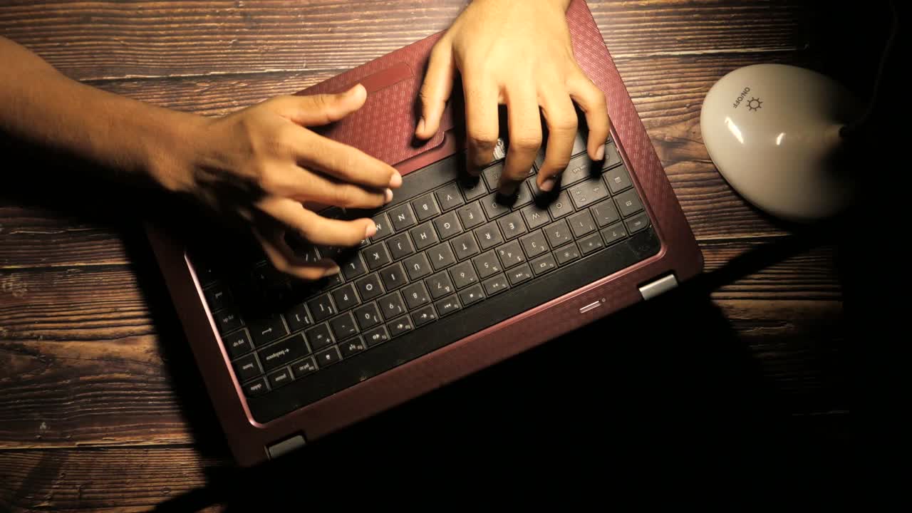 Person Typing on Laptop at Night