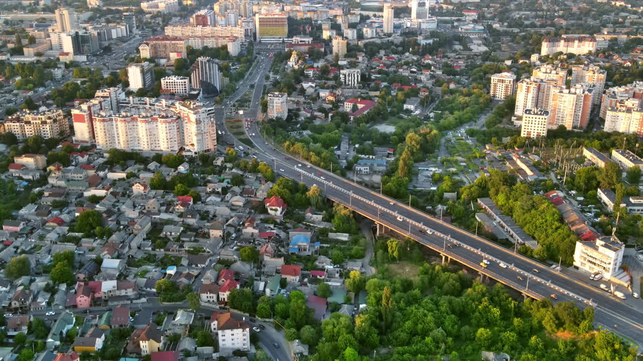 Aerial drone view of Chisinau at sunset. Panorama view of multiple buildings, roads, lush greenery. Moldova