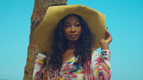 Orbiting-cloe-up-of-a-young-African-girl-face-while-she-is-holding-a-straw-hat