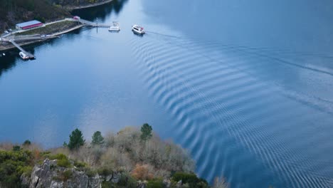 Catamaran-turns-to-line-up-against-pier-causing-ripples-to-break-calm-water-surface