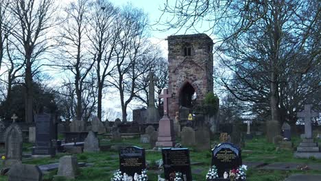 Windleshaw-Chantry-graveyard-and-stonework-tower-exterior-slow-motion-around-ruins-against-blue-sky