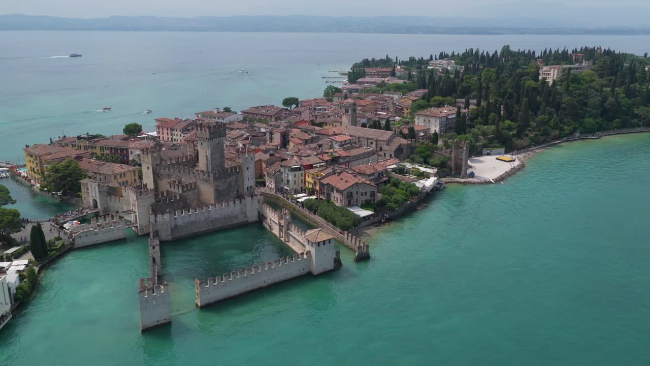 Wide landscape of Sirmione’s old town and castle jutting into Lake Garda