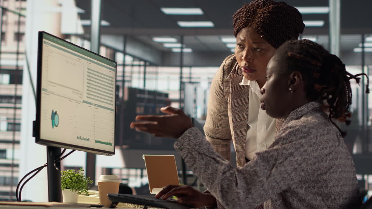 Businesswomen collaborating on data analysis in an office setting