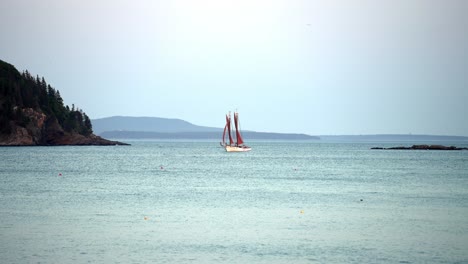 frontal view of sail boat entering marina buoys in slow motion