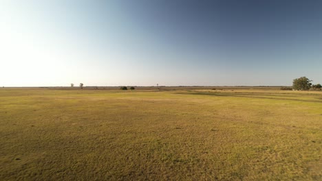 Sobrevuelo-Panorámico-Sobre-Una-Llanura-árida-Acercándose-A-Un-Molino-De-Viento,-Buenos-Aires,-Argentina