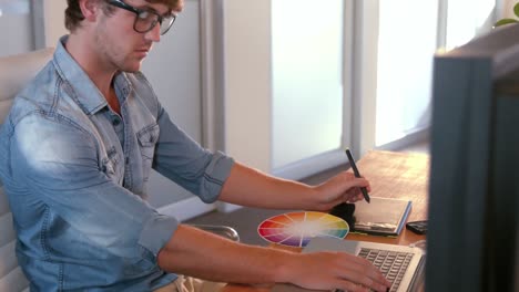 serious handsome designer working with tablet computer