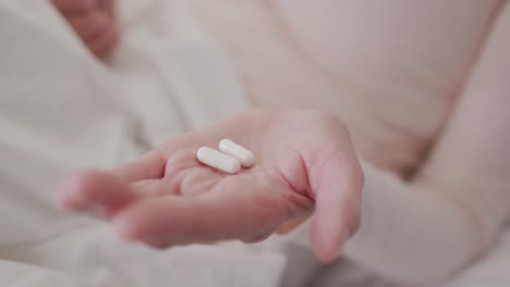 close up of woman holding pills in her hand