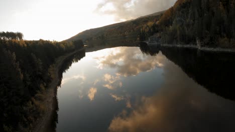 una toma aérea cinematográfica de un lago tranquilo al atardecer