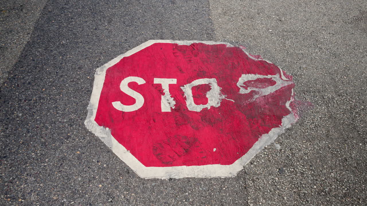 Ruined stop sign painted on the road