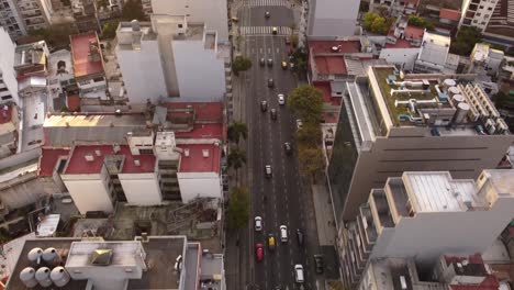 Toma-Aérea-De-Movimiento-De-Tráfico-En-La-Carretera-En-Medio-De-Edificios-Altos-En-La-Avenida-Córdoba-En-Buenos-Aires