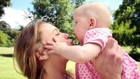 Happy-mother-playing-with-her-baby-girl-in-the-park