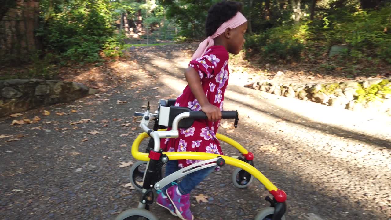 Black girl with Cerebral Palsy walking in the park with her assistive device