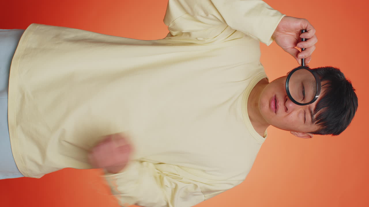 Investigator researcher man with magnifying glass near face looking into camera with big zoom eye