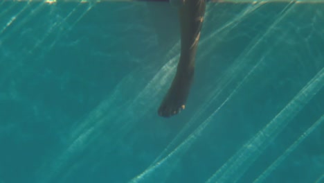 woman paddling her feet in the pool