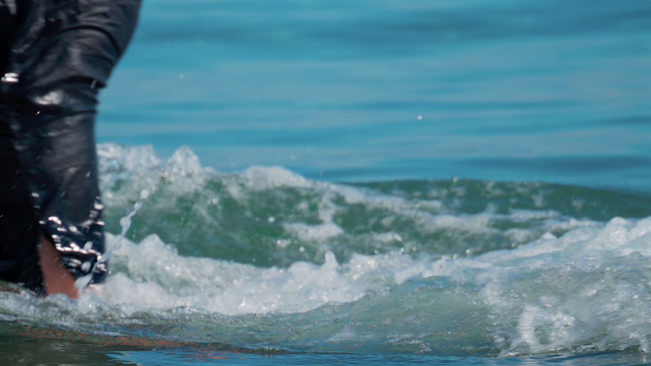 Cannes, France - October 8, 2025: Close up of a boy diving into the clear blue sea, creating a splash around their legs