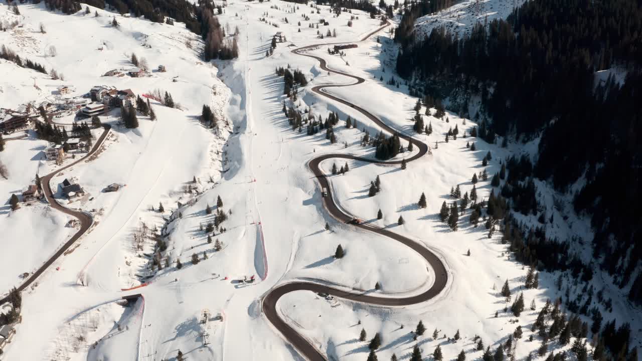 Dolly forward drone shot along beautiful winding mountain road in winter