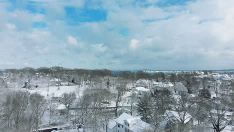 Panorámica-Aérea-De-Izquierda-A-Derecha-De-Casas-Cubiertas-De-Nieve-En-Crow-Point,-Ma,-Estados-Unidos