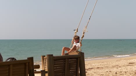 Junge-In-Zeitlupe-Beim-Schaukeln-Am-Exotischen-Strand-In-Asien