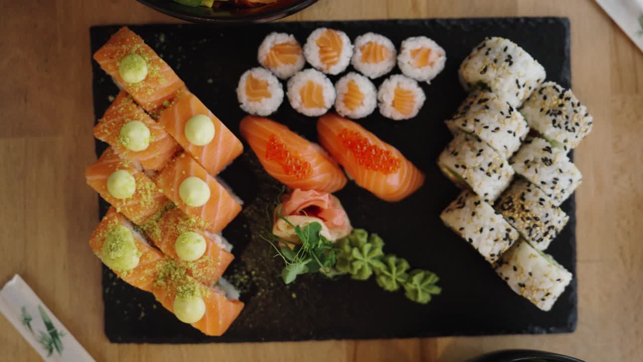 Top down view of salmon sushi set plate with poke bowl and edamame beans side