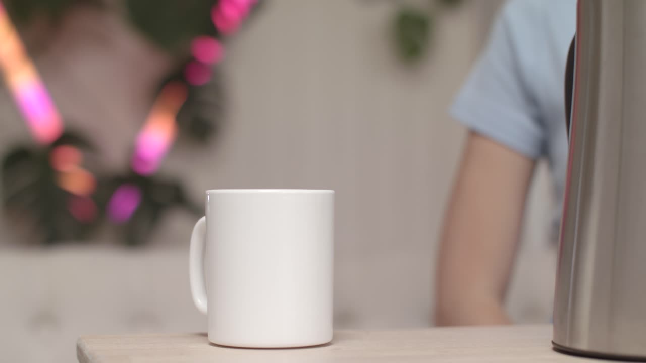 persona sentada bebiendo café o té de una taza blanca