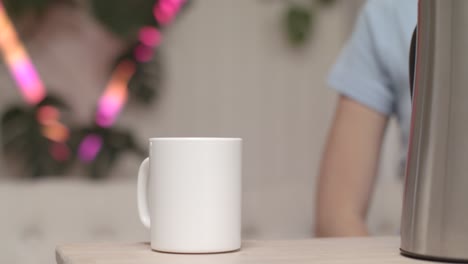 person sitting and drinking coffee/tea from a white mug