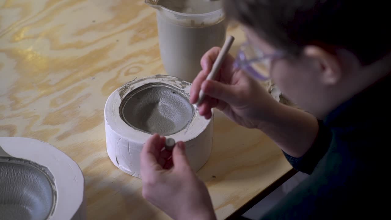 Woman creating a pottery bowl using a mold