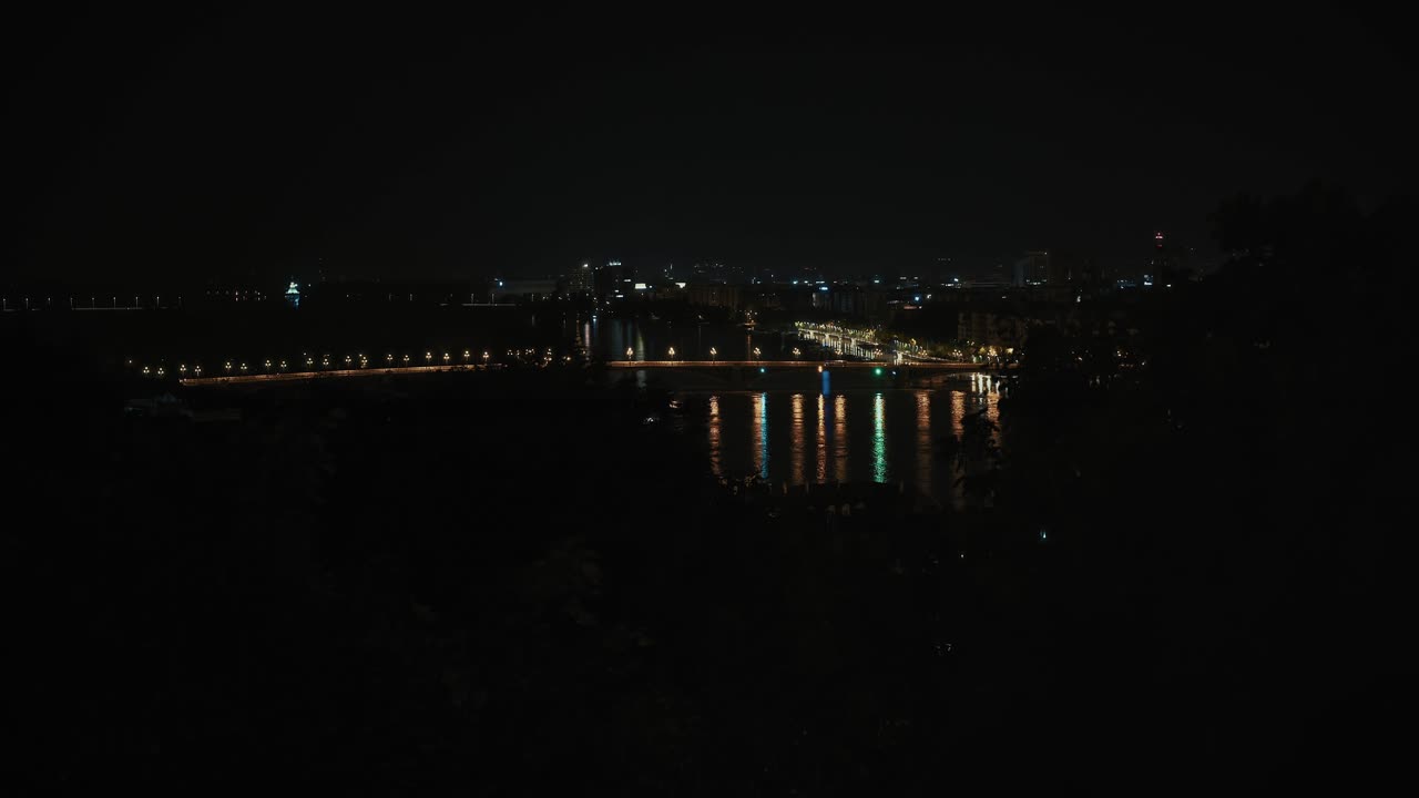 las aguas de la inundación del danubio reflejando las luces de la ciudad desde una vista nocturna lejana de budapest