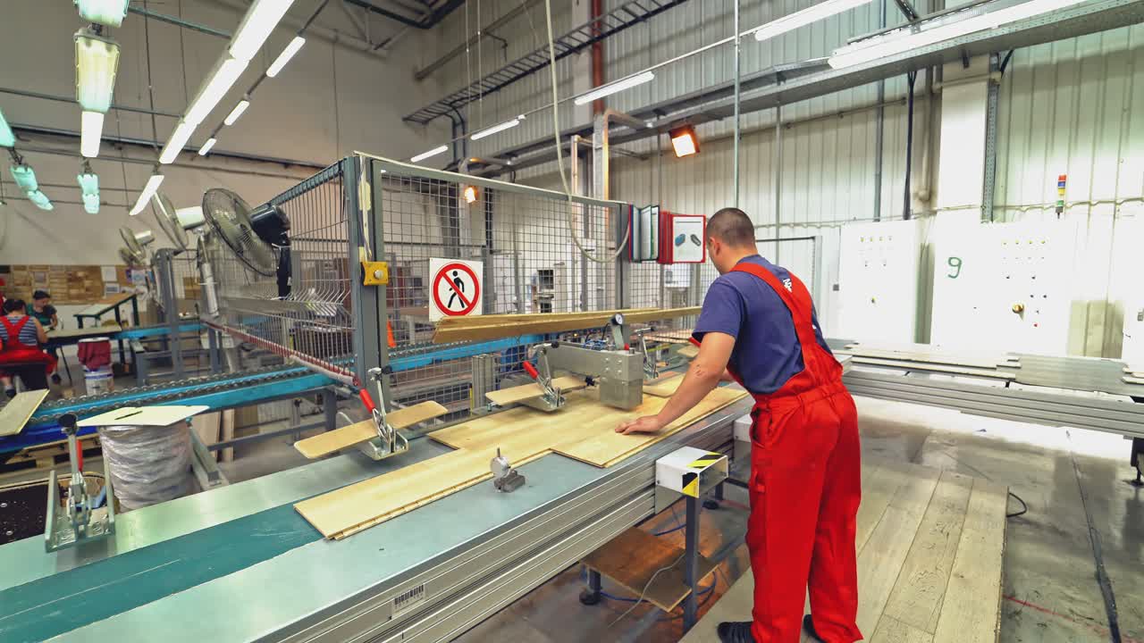 Falegname al lavoro con un utensile industriale in una fabbrica di legno. Produzione di pavimenti, lavorazione del parquet.
