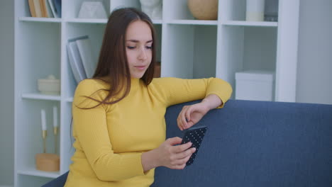 un retrato en primer plano de una agradable mujer de mediana edad con cabello claro que está en la oficina y acostada en el sofá y hablando en un enlace de video en el teléfono en casa sosteniéndolo a la longitud del brazo