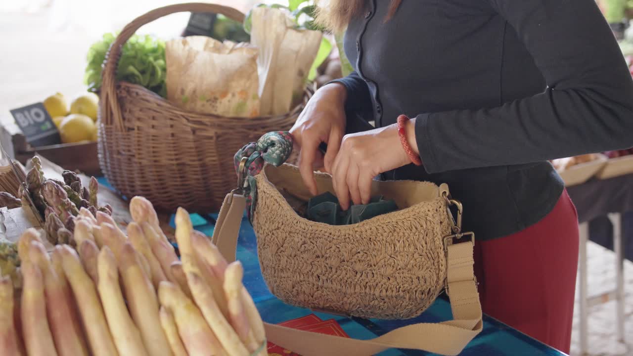 Searching for money at outdoor produce stall