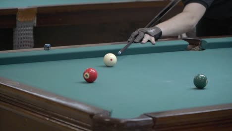 a player hammers a ball into a corner pocket during a pool game.