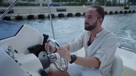 man steering a boat on the water