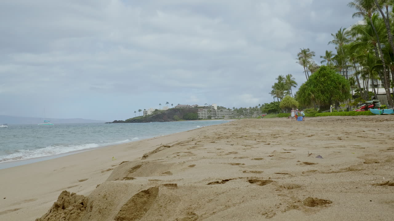 vista de cerca de las olas rodando en una playa de arena por la noche bajo un cielo nublado