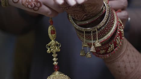 closeup hands of an indian bride wearing bridal latkan chuda bangles