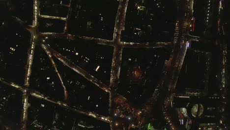 AERIAL:-Slow-Overhead-Shot-of-City-at-Night-with-Lights-and-Traffic,-Cologne,-Germany