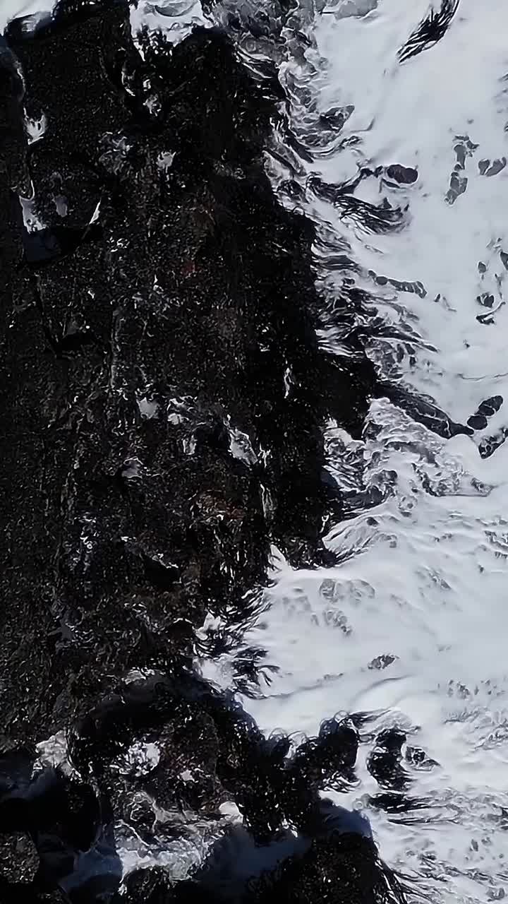 Le onde si infrangono contro la costa rocciosa in Cile durante una giornata di sole.