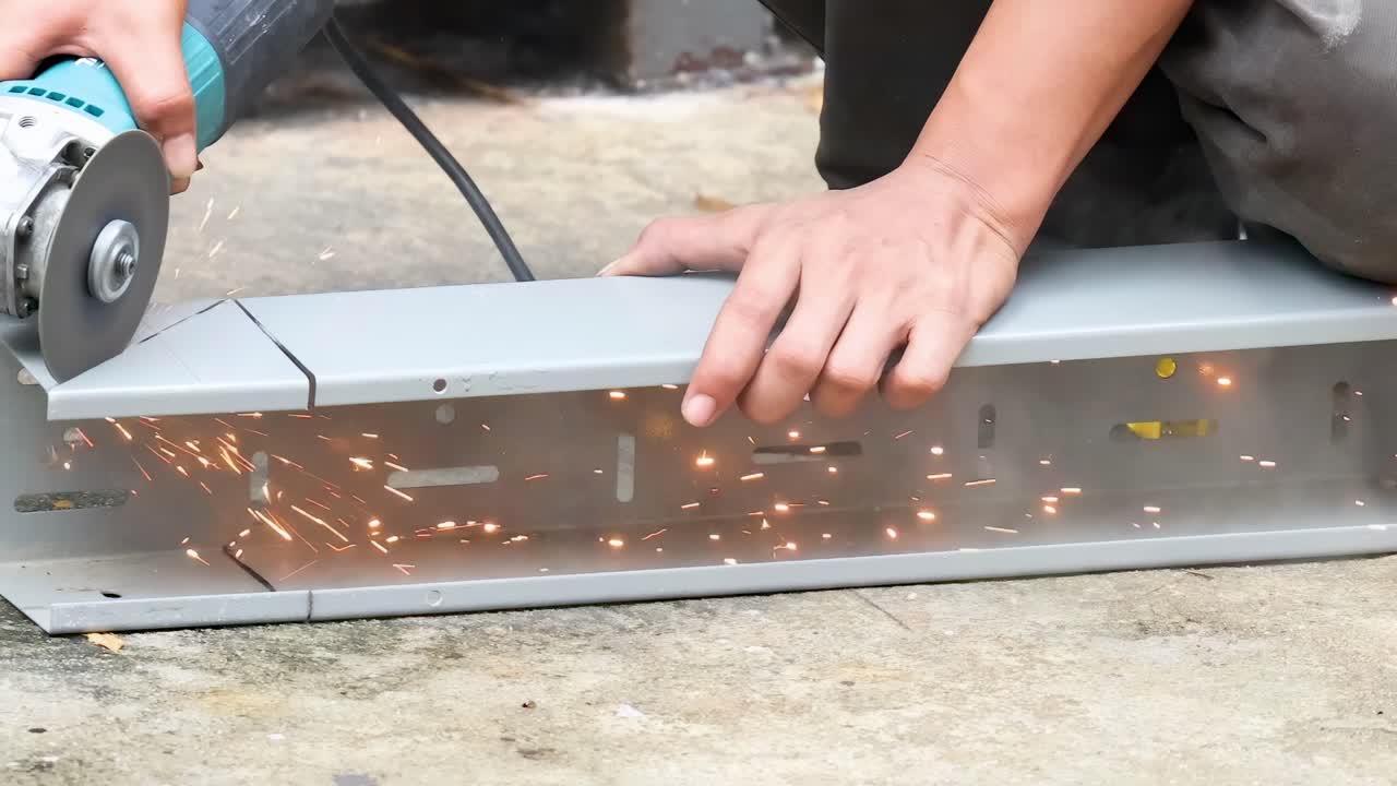 금속 조각을 잘라내기 위해 밀러를 사용하는 노동자