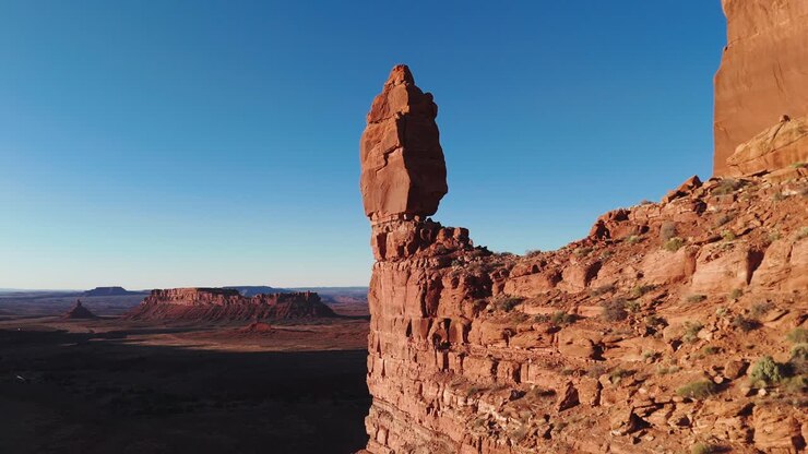 Aerial pass by balancing rock to reveal Utah desert at sunset