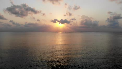 Flying-over-the-ocean-as-the-sun-sets-on-the-horizon