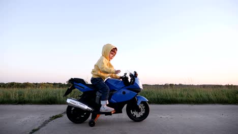 little boy is riding an electric motorcycle toy