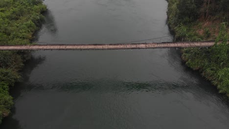 old wooden suspension bridge crossing a river at vietnam, aerial